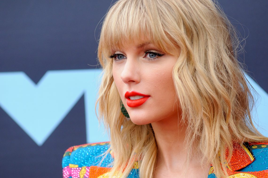Tekst o walce Taylor Swift o niezależność i feminizm. Na zdjęciu: Kobieta z blond włosami i czerwoną szminką - HelloZdrowie