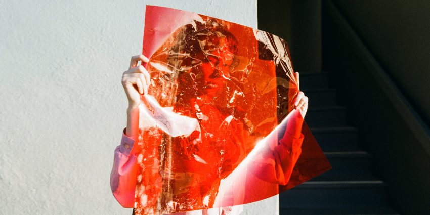 Kobieta trzyma przed sobą czerwoną folię