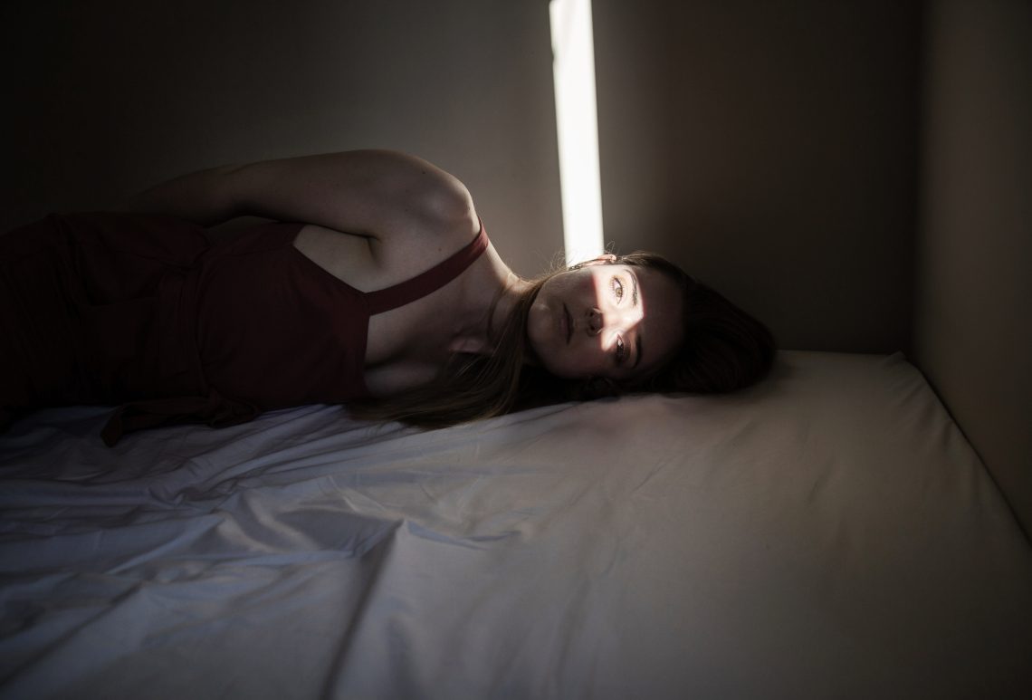 Tekst o prawach kobiet po poronieniu i problemach. Na zdjęciu: Kobieta leżąca na łóżku - HelloZdrowie