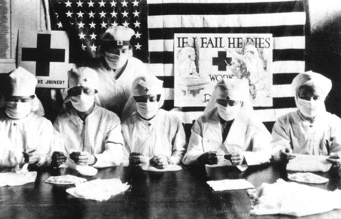 Tekst o pandemii grypy z lat 1918-1920. Na zdjęciu: Grupa ludzi w maseczkach i białych fartuchach - HelloZdrowie