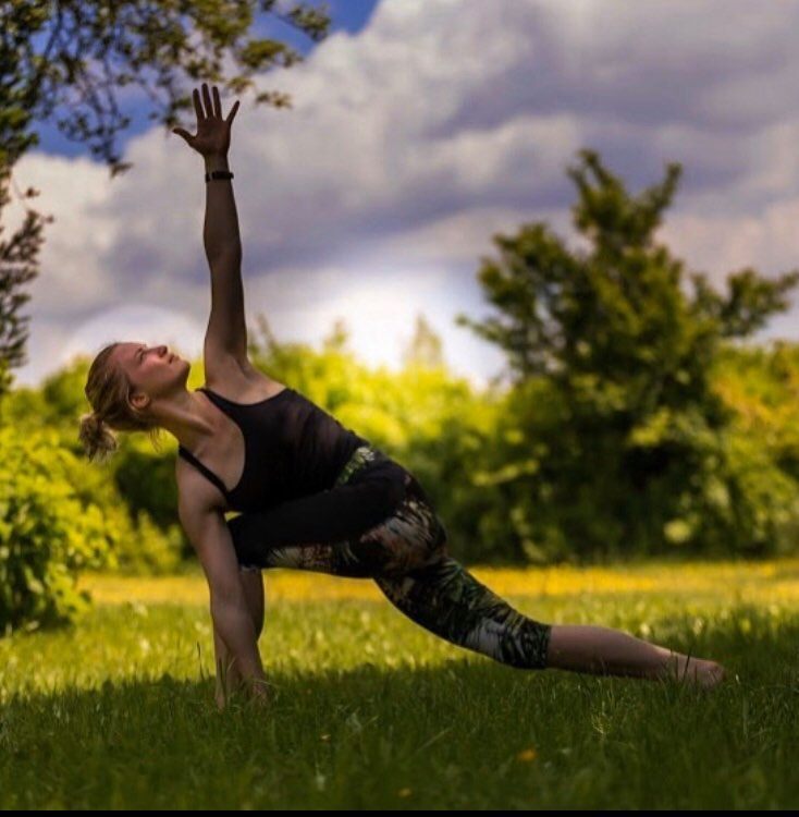 Tekst o drodze i filozofii nauczycielki jogi. Na zdjęciu: Kobieta wykonująca jogę na trawiastym terenie - HelloZdrowie