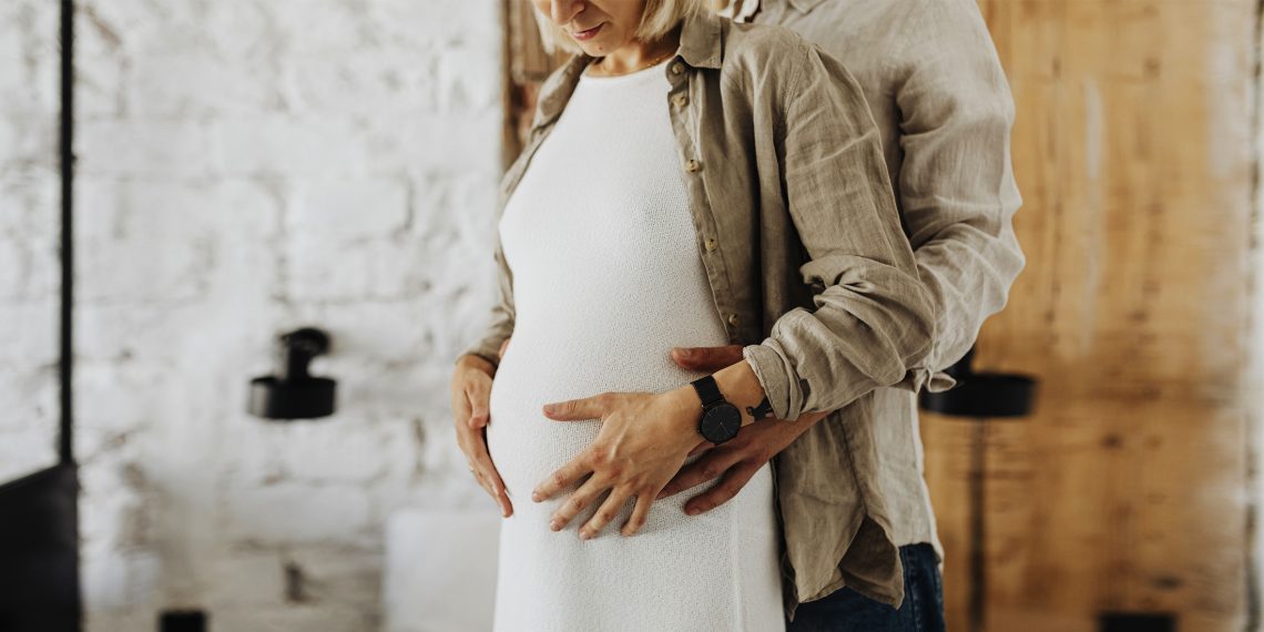 Tekst o roli miednicy w porodzie i jej anatomii. Na zdjęciu: Mężczyzna i kobieta trzymający brzuch - HelloZdrowie