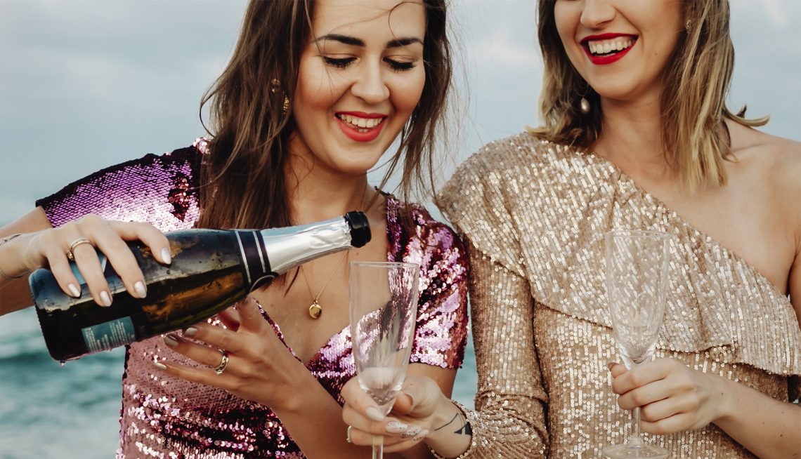 Tekst o wpływie spożywania alkoholu na organizm. Na zdjęciu: Kobieta nalewa szampana do kieliszka - HelloZdrowie