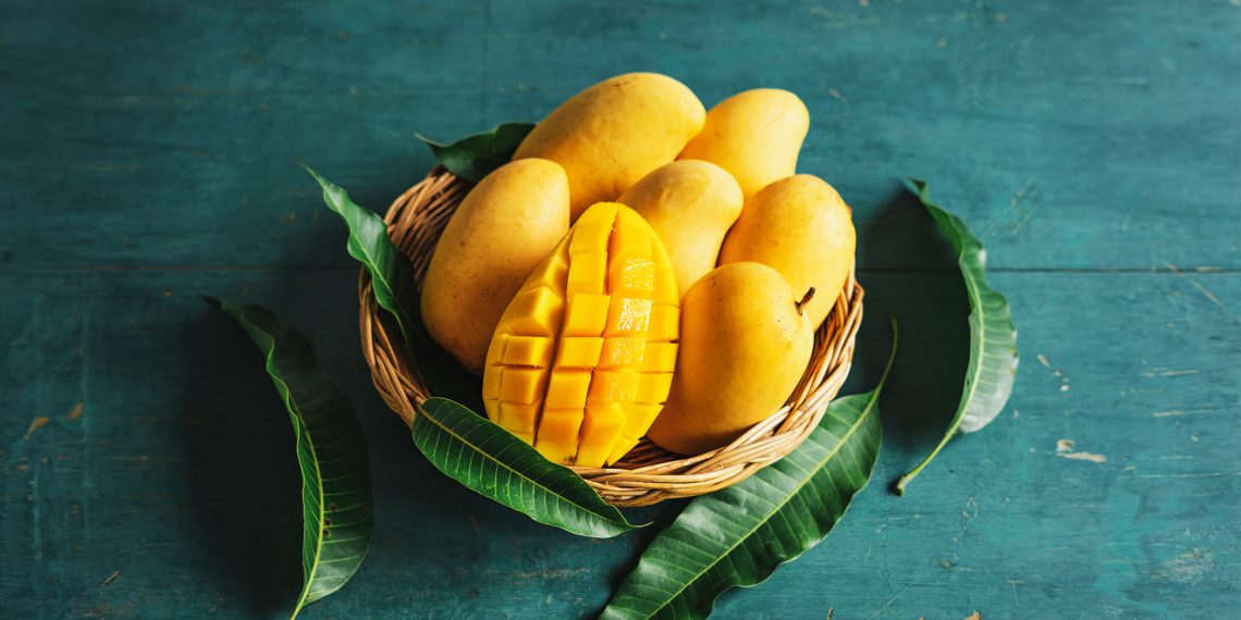 Tekst o zdrowotnych właściwościach i zastosowaniach mango. Na zdjęciu: Koszyk mango i kawałek mango - HelloZdrowie