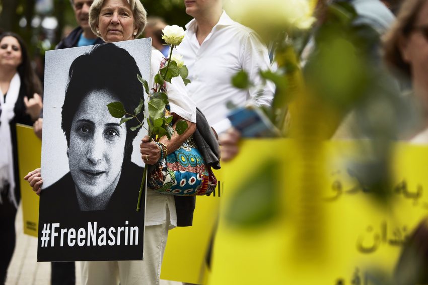 Tekst o Nasrin Sotoudeh i jej walce o prawa człowieka. Na zdjęciu: Kobieta trzymająca różę i znak - HelloZdrowie