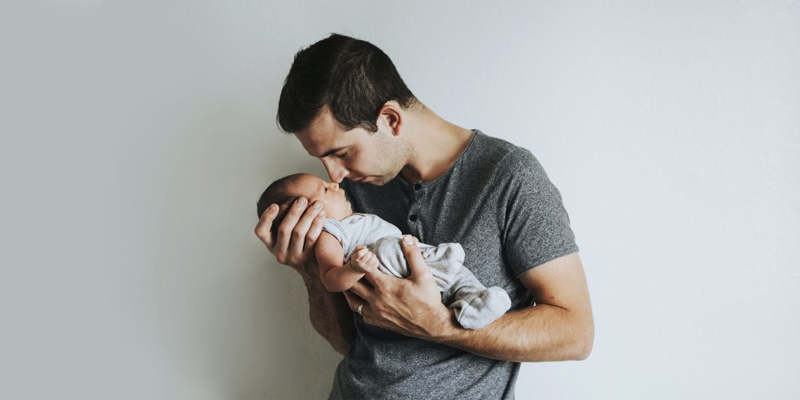Tekst o urlopach ojcowskich i tacierzyńskich w 2020 r. Na zdjęciu: Mężczyzna trzymający dziecko - HelloZdrowie