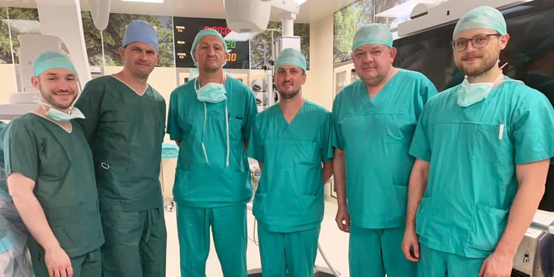 Tekst o współpracy synów słynnych kardiochirurgów. Na zdjęciu: Grupa mężczyzn ubranych w strój chirurgiczny i czepki chirurgiczne - HelloZdrowie