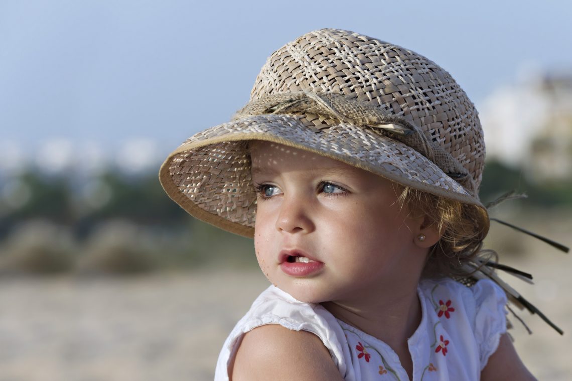 Tekst o przekłuwaniu uszu niemowlętom i kontrowersjach z tym związanych. Na zdjęciu: Dziecko noszące czapkę - HelloZdrowie