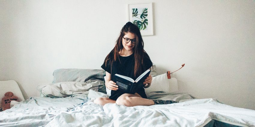 dziewczyna na łóżku z książką
