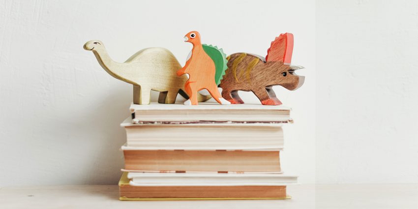 Książki a na nich figurki dinozaurów