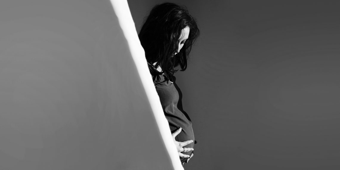 Tekst o wpływie wyroku TK na aborcje embrio-patologiczne. Na zdjęciu: Kobieta w ciąży trzymająca swoje brzuch - HelloZdrowie