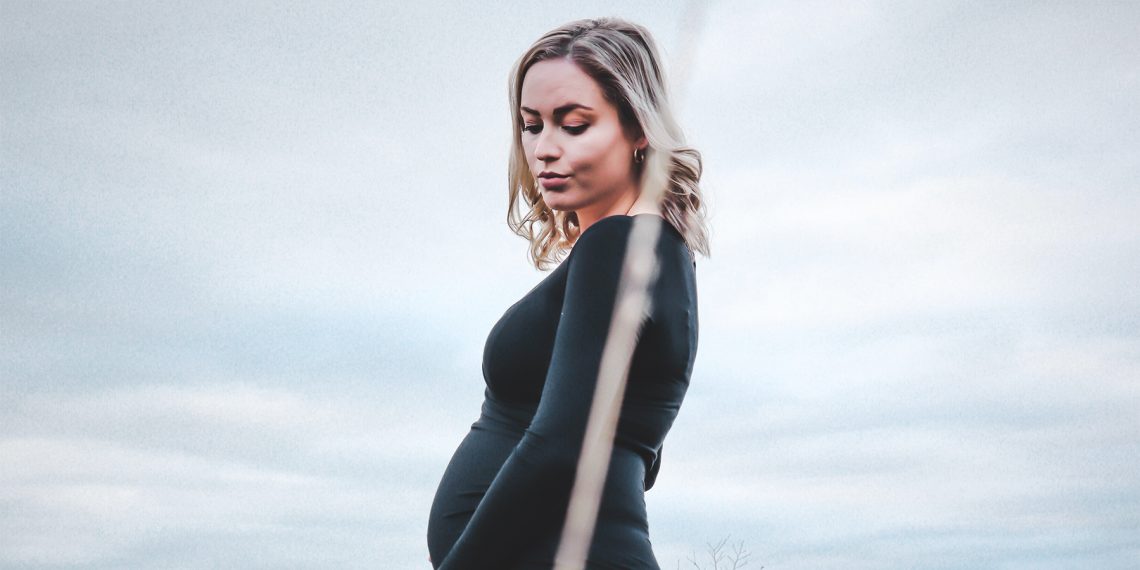 Tekst o badaniu prenatalnym Sanco i jego zaletach. Na zdjęciu: Kobieta w ciąży w czarnej sukience - HelloZdrowie