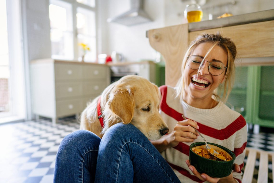 Tekst o diecie ubogoresztkowej i jej zastosowaniu medycznym. Na zdjęciu: Kobieta i pies siedzą na podłodze - HelloZdrowie