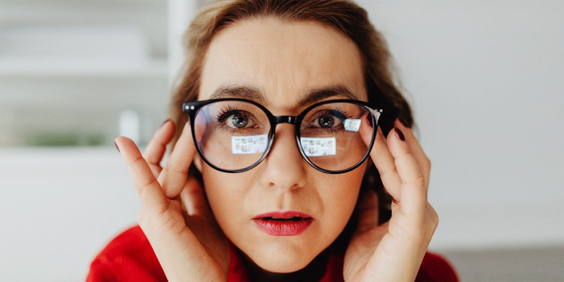 Tekst o plamce ślepej i jej wpływie na widzenie. Na zdjęciu: Kobieta z okularami i czerwoną szminką - HelloZdrowie