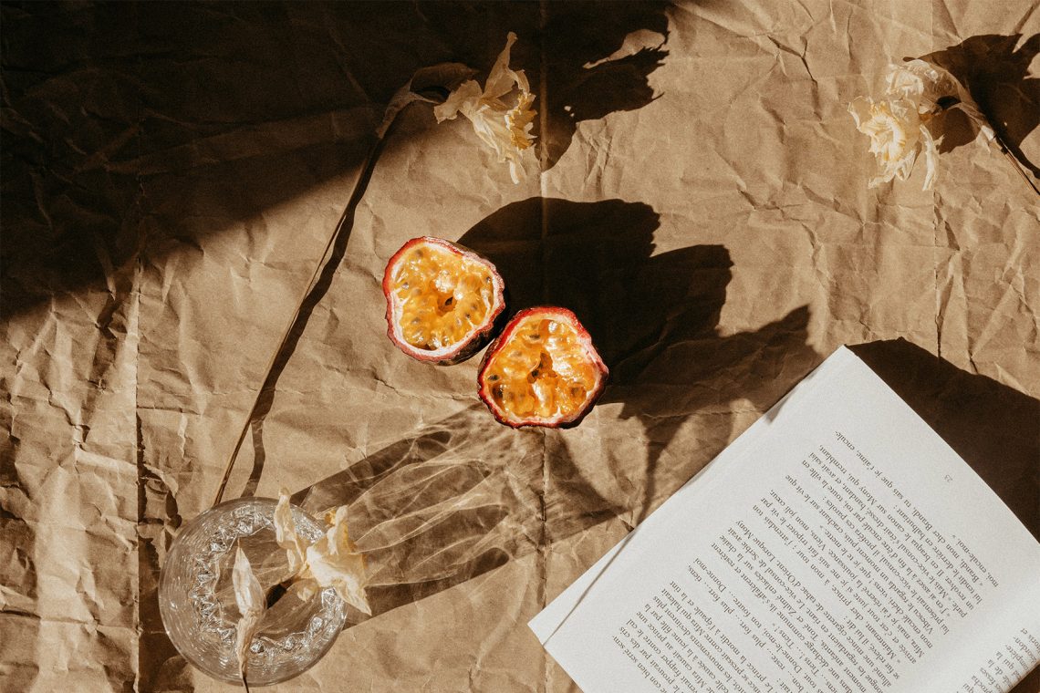 Tekst o marakui: właściwości, spożycie, przepisy kulinarne. Na zdjęciu: Kawałek papieru ze zdjęciem kwiatu i szkłem na nim - HelloZdrowie