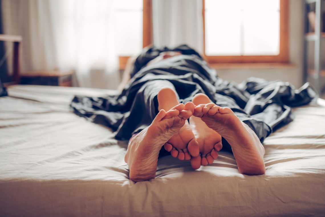 Tekst o rozpoznawaniu orgazmu według Katarzyny Koczułap. Na zdjęciu: Osoba leżąca na łóżku z nogami do góry - HelloZdrowie