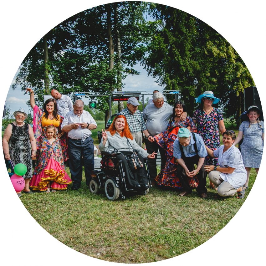 Tekst o pracownicy socjalnej na wózku inwalidzkim. Na zdjęciu: Grupa osób pozujących do zdjęcia - HelloZdrowie