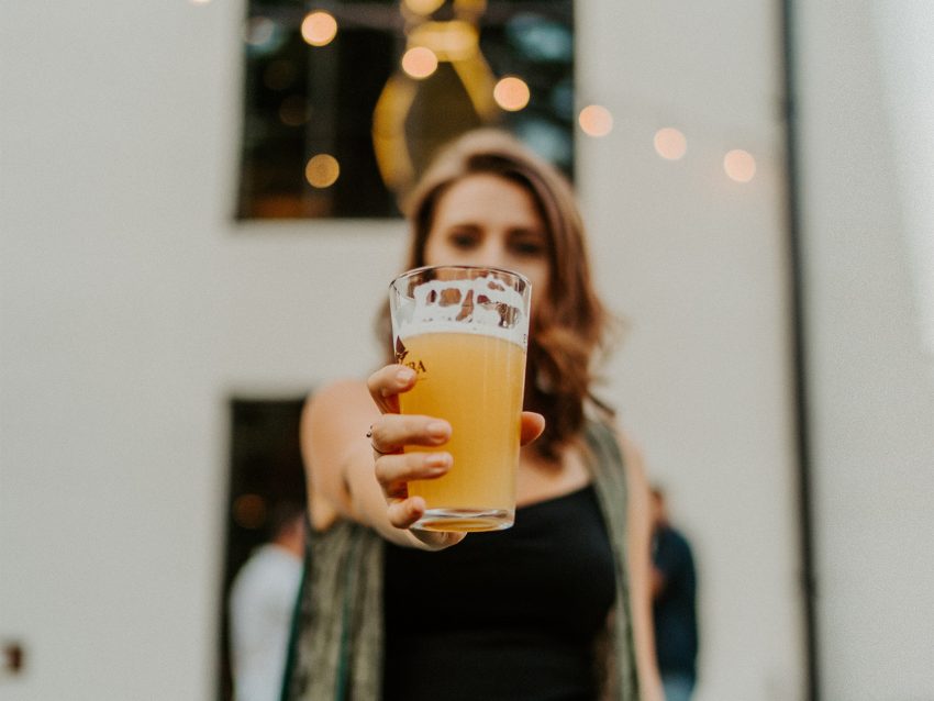 Kobieta trzyma w ręce szklankę piwa