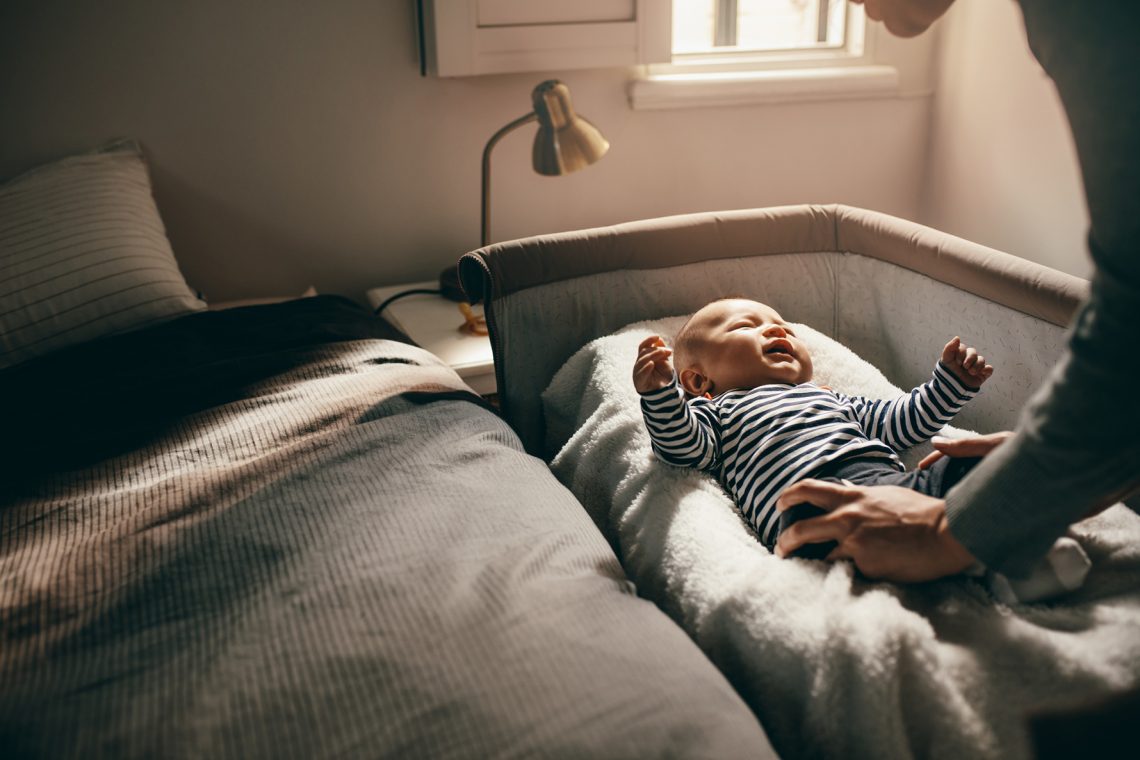 Tekst o poprawie jakości snu niemowlaka. Na zdjęciu: Dziecko leżące na łóżku - HelloZdrowie