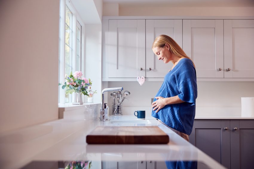 Kobieta w ciąży stoi w kuchni