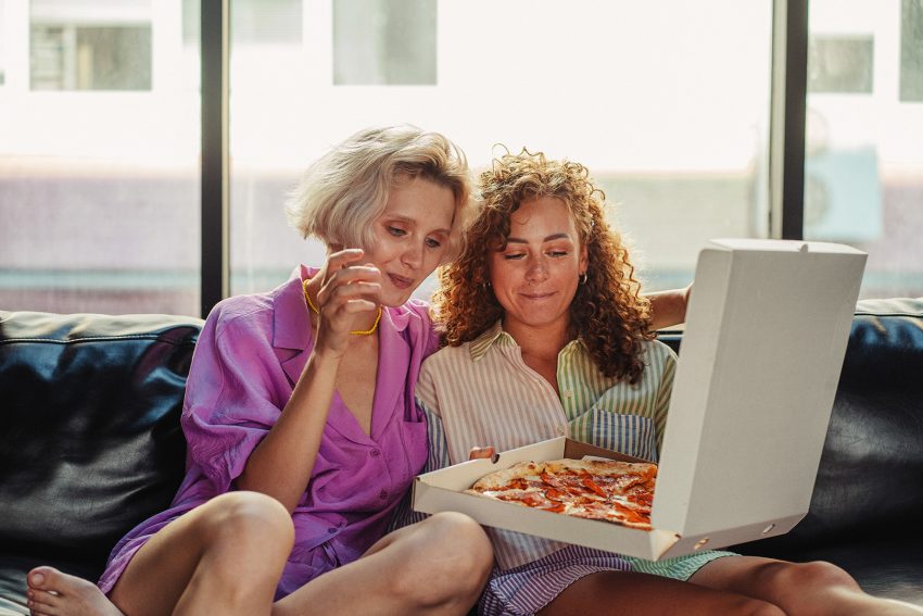 Kobiety trzymają pizzę