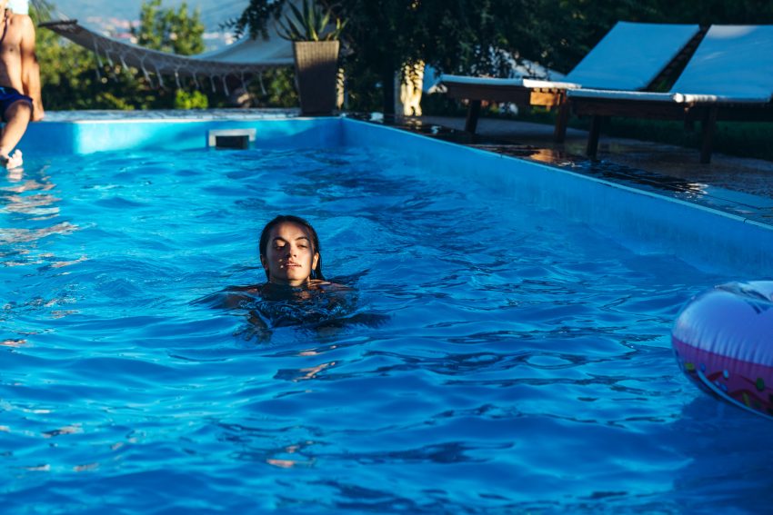 Kobieta pływa w basenie ogrodowym