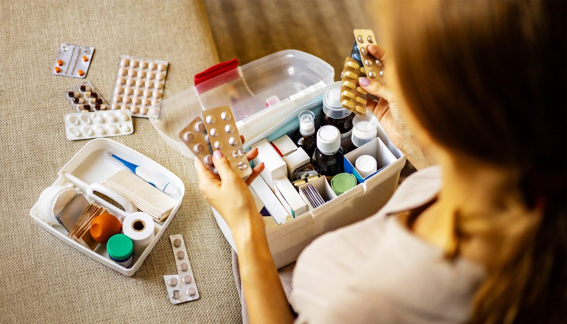 Kobieta wyciąga tabletki z pudełka na leki