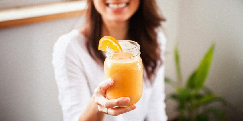 Życie bez cukru. Co się zadzieje, kiedy odstawisz słodkości, na zdjęciu kobieta trzymająca szklankę soku pomarańczowego- Hello Zdrowie