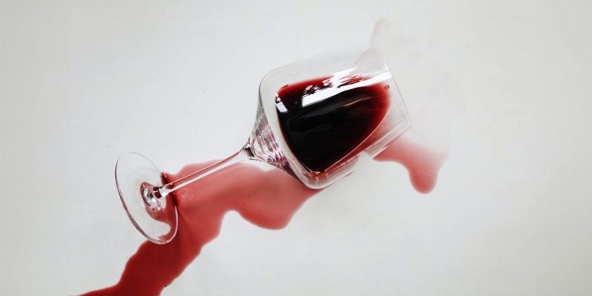 Na zdjęciu przechylony kieliszek z winem- HelloZdrowie