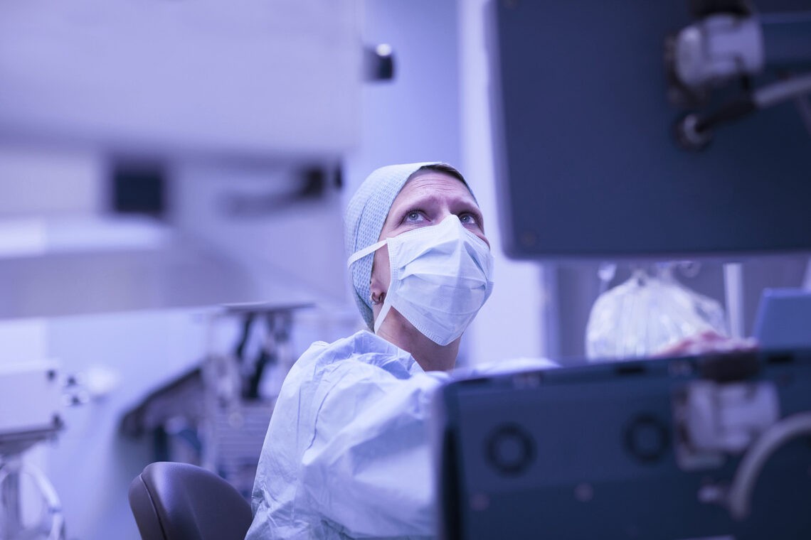 Chirurdzy z Oksfordu przeprowadzili pierwszy w Wielkiej Brytanii przeszczep macicy - na zdjęciu lekarka patrzy w monitor, na twarzy ma maseczkę HelloZdrowie
