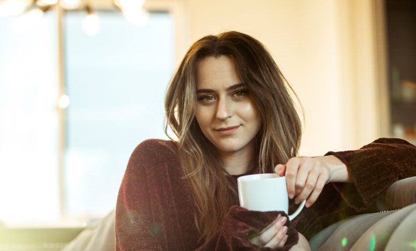 Kobieta odpoczywa z kubkiem herbaty w dłoni. Tekst dotyczy laktoferyny - HelloZdrowie