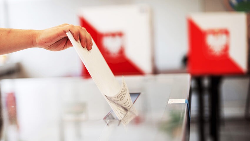 Na zdjęciu widoczna ręka Polaka wrzucającego kartę wyborczą do urny- HelloZdrowie
