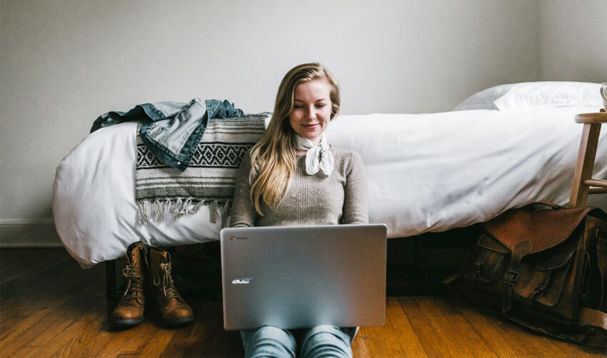 Na zdjęciu kobieta siedząca na podłodze z laptopem na kolanach- HelloZdrowie