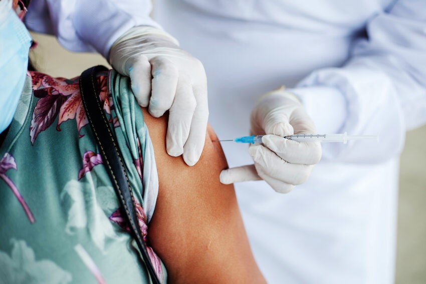 Szczepionka przeciw grypie zmniejsza ryzyko hospitalizacji o połowę - na zdjęciu pacjentka otrzymuje szczepionkę HelloZdrowie