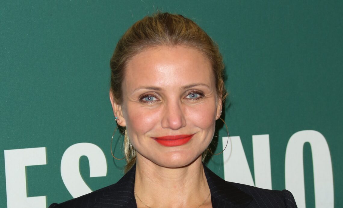 Cameron Diaz o tym, że oddzielne sypialnie powinny być normą - na zdjęciu aktorka pozuje na zielonej ściance ma związane w kucyk włosy i czerwoną pomadkę na ustach Hello Zdrowie