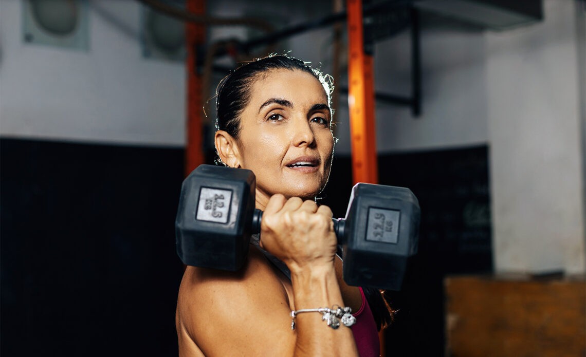 Nagły przyrost masy ciała staje się realnym problemem dla kobiet w okresie menopauzy - na zdjęciu kobieta trzyma ciężarek gimnastyczny Hello Zdrowie