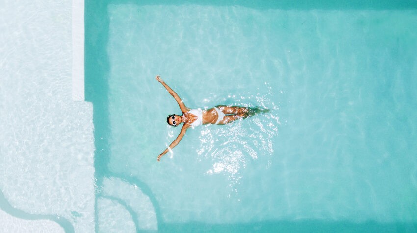Okres a basen – czy to bezpieczne połączenie?; na zdjęciu kobieta pływająca w basenie- Hello Zdrowie