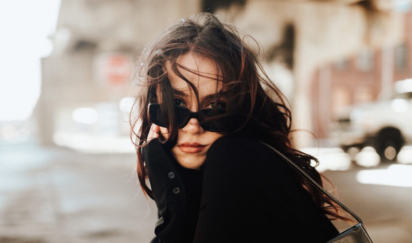 Co powoduje pogorszone samopoczucie przed okresem; na zdjęciu kobieta w czarnych okularach przeciwsłoneczych- Hello Zdrowie