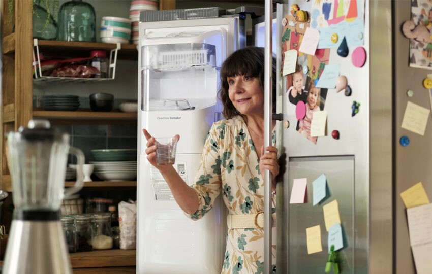 Agnieszka Suchora w filmie "Miłość ja miód" - stoi przy lodówce, bo ma uderzenia gorąca z powodu menopauzy
