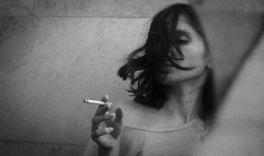 Kobieta pali papierosa, czarno-białe zdjęcie - Hello Zdrowie