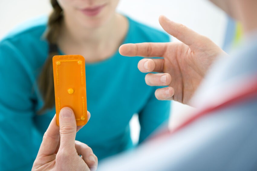 Lekarz podaje pacjentce blister z tabletką
