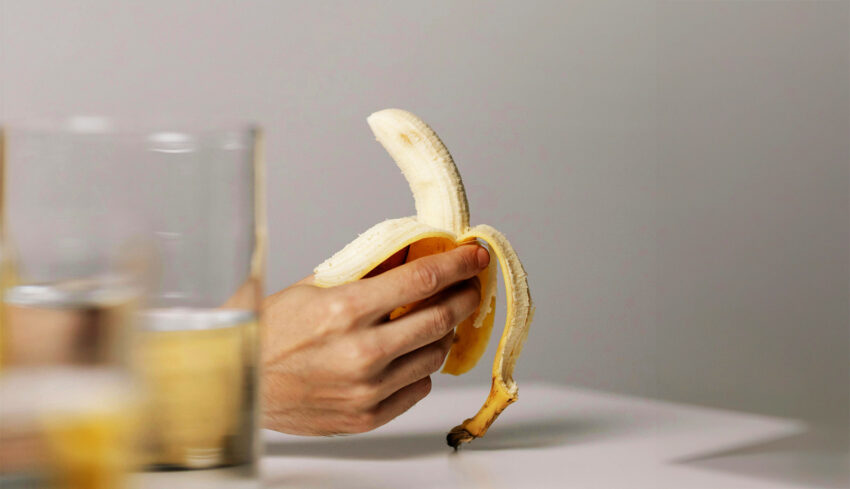 Na zdjęciu banan obrany do połowy - HelloZdrowie