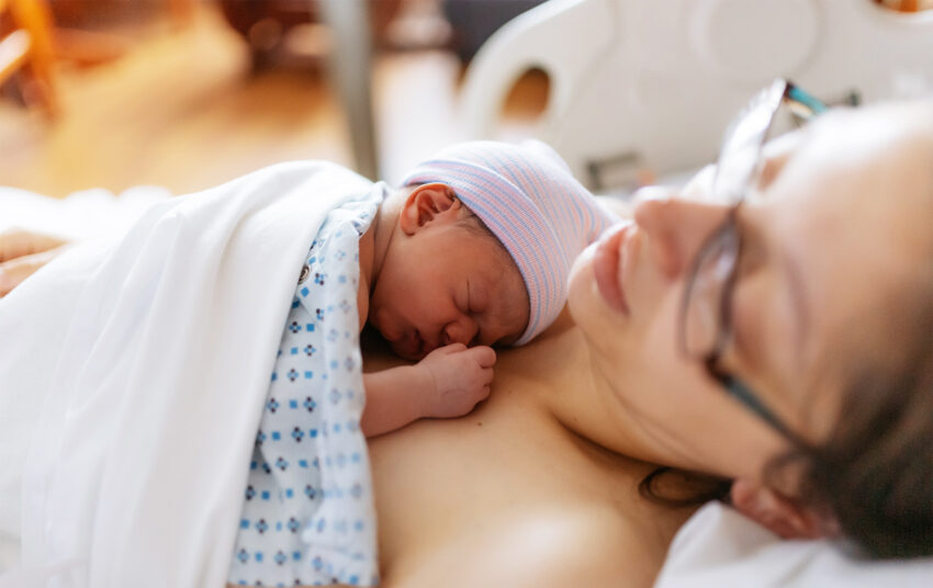 Na zdjęciu młoda mama z noworodkiem, chwilę po porodzie- Hello Zdrowie