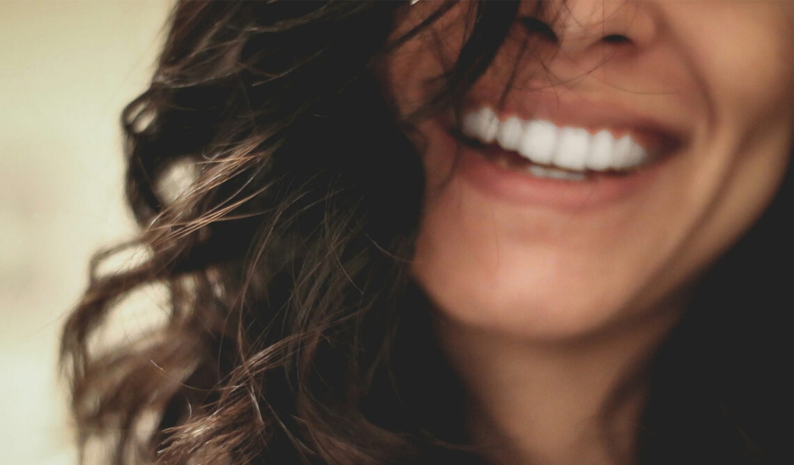 Uśmiechnięta kobieta z pięknymi zębami. Tekst dotyczy irygatorów - Hello Zdrowie