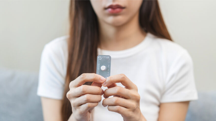 Nastolatka trzyma w dłoniach tabletkę