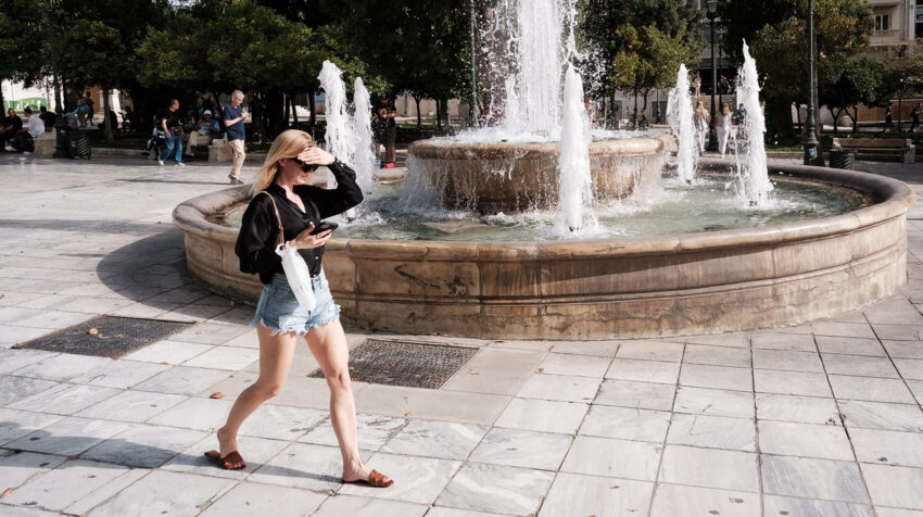 Kobieta przechodzi obok fontanny