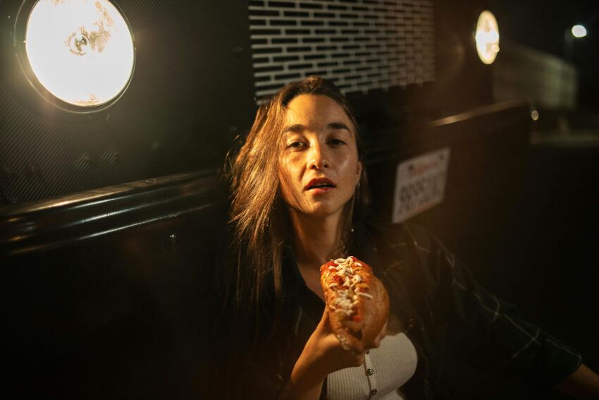 Na zdjeciu: kobieta trzyma w dłoni hamburgera, tekst o życiu z bulimią /fot. Pexels