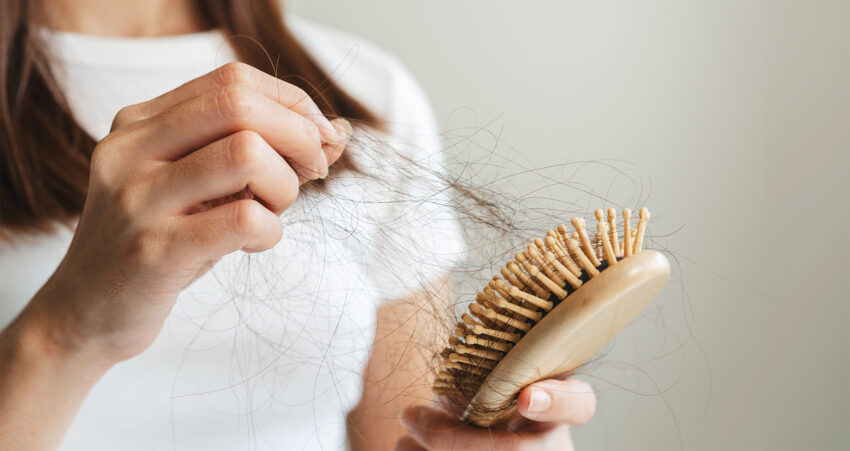 Kobieta zdejmuje włosy ze szczotki\ Adobe Stock