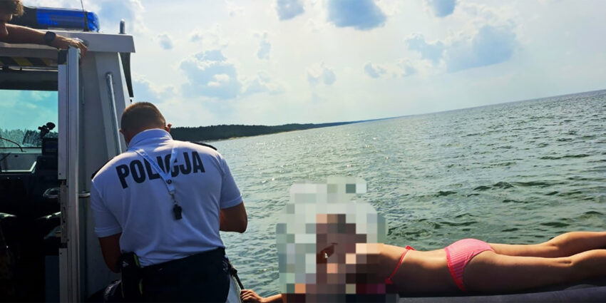 Policja i kobieta na materacu na morzu