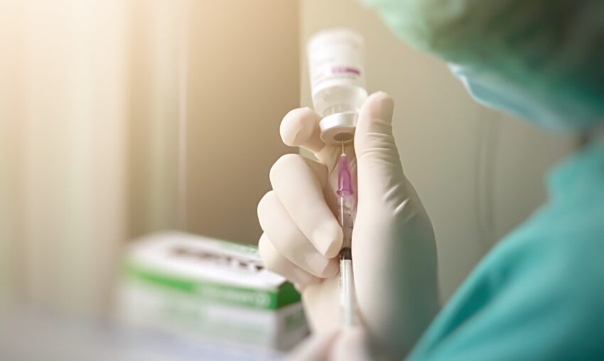 Pielęgniarka nabiera preparat szczepionki w strzykawkę
